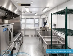 Bright commercial mobile kitchen with stainless steel prep tables, shelving, sinks, and cooking equipment.